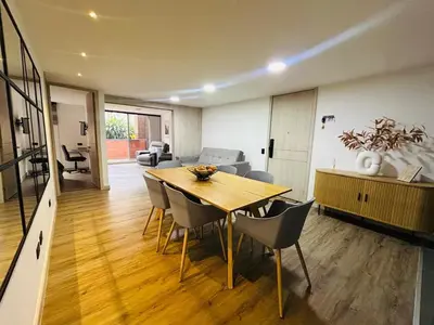 a dining room and living room with a table and chairs at Modern, Apt/near tourist sites. in Medellín