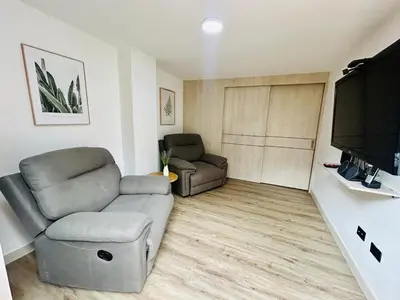a living room with a couch and a flat screen tv at Modern, Apt/near tourist sites. in Medellín