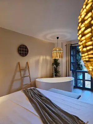 a bedroom with a tub and a bed and a table at Poblado Luum Boutique hotel in Medellín