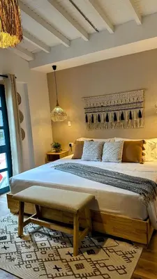 a bedroom with a large bed with a bench on a rug at Poblado Luum Boutique hotel in Medellín