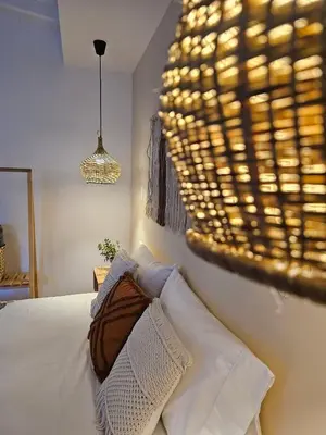 a bedroom with a bed and a chandelier at Poblado Luum Boutique hotel in Medellín