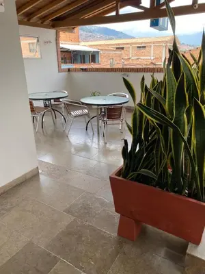 a room with tables and chairs and a potted plant at Hotel Park Caribe in Medellín
