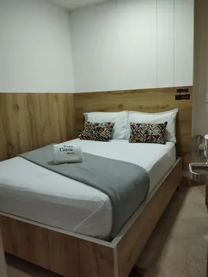 a large bed with a wooden headboard in a bedroom at Hotel Park Caribe in Medellín
