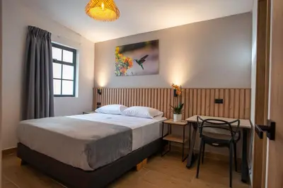 a bedroom with a bed and a table with a chair at Vita Hotel Boutique - Aire Acondicionado & Desayuno in Medellín