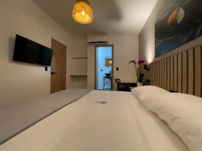 a bedroom with a large white bed with a flat screen tv at Vita Hotel Boutique - Aire Acondicionado & Desayuno in Medellín