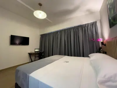 a bedroom with a large white bed and a tv at Vita Hotel Boutique - Aire Acondicionado & Desayuno in Medellín