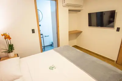 a bedroom with a white bed and a tv at Vita Hotel Boutique - Aire Acondicionado & Desayuno in Medellín