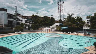 a large swimming pool with blue water in a city at Encantador Apartamento Ciudadela in Santa Fe de Antioquia