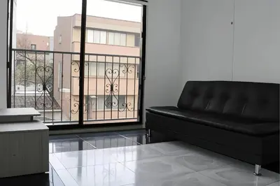 a black couch in a room with a large window at Aparta Suite Torre De Prado 501 in Medellín