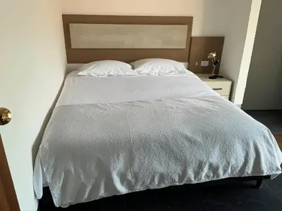 a large bed with white sheets and pillows at Aparta Suite Torre De Prado 501 in Medellín