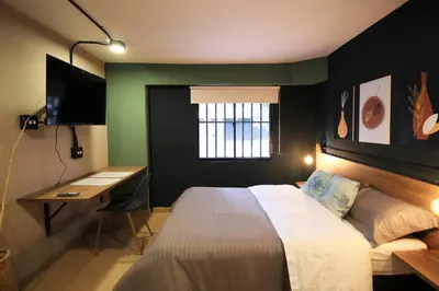 a bedroom with a bed and a desk and a window at Apartamento doble con baño privado y Wifi -ONE101 By Roots Rentals in Medellín