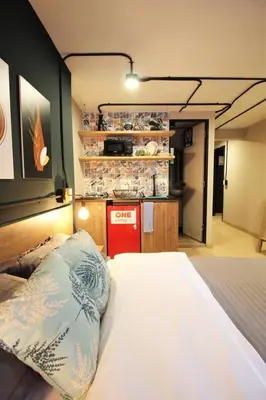 a bedroom with a bed and a kitchen in the background at Apartamento doble con baño privado y Wifi -ONE101 By Roots Rentals in Medellín