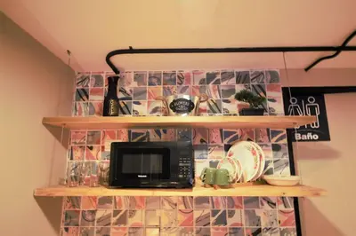 a shelf with a microwave on top of it at Apartamento doble con baño privado y Wifi -ONE101 By Roots Rentals in Medellín