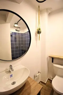a bathroom with a sink and a mirror and a toilet at Apartamento con puesto de trabajo ONE102 By Roots Rentals in Medellín