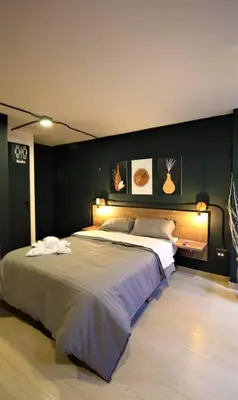 a bedroom with a large bed with a black wall at Apartamento con puesto de trabajo ONE102 By Roots Rentals in Medellín