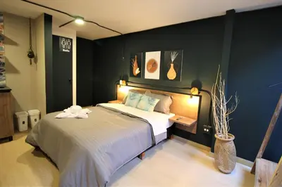 a bedroom with a large bed with a black wall at Apartamento con puesto de trabajo ONE102 By Roots Rentals in Medellín