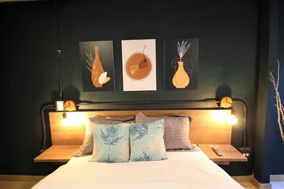 a bedroom with a bed with some pictures on the wall at Apartamento con puesto de trabajo ONE102 By Roots Rentals in Medellín