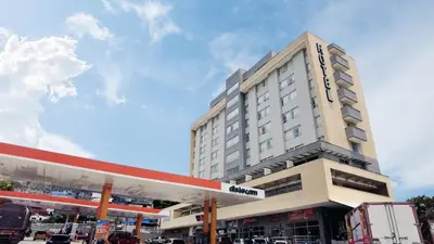 a building with a gas station in front of it at Hotel Las Olas Bello in Machado