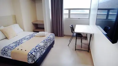 a bedroom with a bed and a desk and a window at Hotel Las Olas Bello in Machado