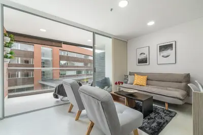 a living room with a couch and a table and chairs at PORTANOVA Suites by ADVENTU in Rionegro