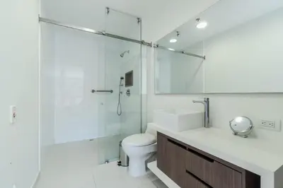 a bathroom with a shower and a toilet and a sink at PORTANOVA Suites by ADVENTU in Rionegro