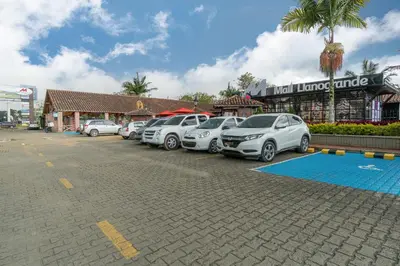 a row of cars parked in a parking lot in front of a store at PORTANOVA Suites by ADVENTU in Rionegro