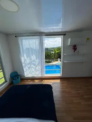 a bedroom with a large window and a swimming pool at La Martina Palestina in Palestina