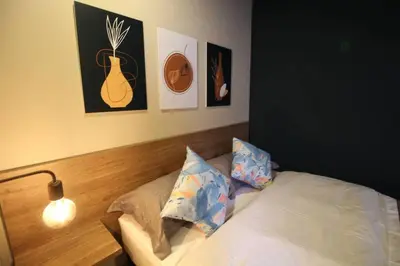 a bedroom with a bed and some pictures on the wall at Estudio sector Universidad de Medellín - ONE205 By Roots Rentals in Medellín