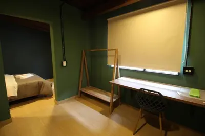 a room with a bed and a table and a chair at Estudio sector Universidad de Medellín - ONE205 By Roots Rentals in Medellín