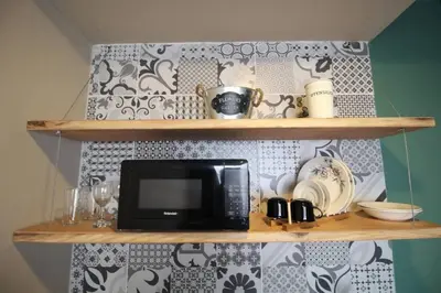 a microwave on a shelf in a kitchen at Estudio sector Universidad de Medellín - ONE205 By Roots Rentals in Medellín