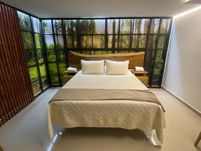 a bedroom with a large bed and large windows at Maidy Luxury Hotel in Medellín