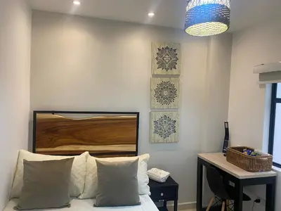 a bedroom with a bed and a desk and a lamp at Maidy Luxury Hotel in Medellín