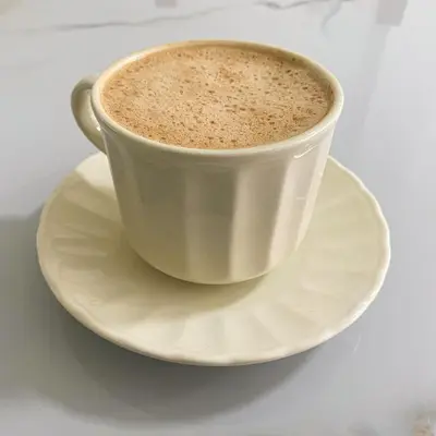 a cup of coffee on a plate on a table at Maidy Luxury Hotel in Medellín