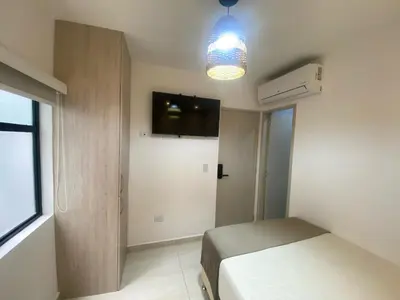 a small bedroom with a bed and a window at Maidy Luxury Hotel in Medellín