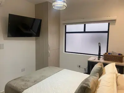 a bedroom with a bed and a flat screen tv at Maidy Luxury Hotel in Medellín