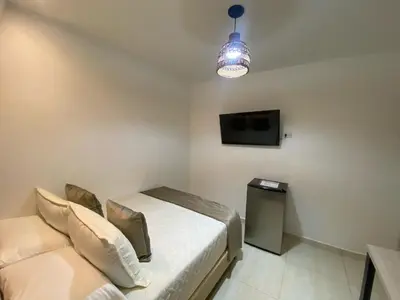 a bedroom with a bed and a tv and a couch at Maidy Luxury Hotel in Medellín