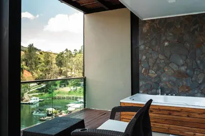 a balcony with a tub and a view of a river at Hotel Nova El Peñol in El Peñol