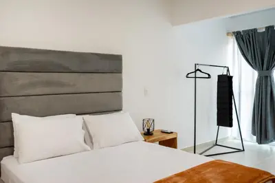 a bedroom with a large white bed and a window at Hotel Nova El Peñol in El Peñol