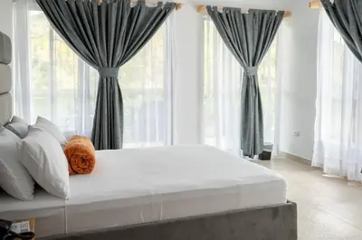 a large white bed in a room with windows at Hotel Nova El Peñol in El Peñol