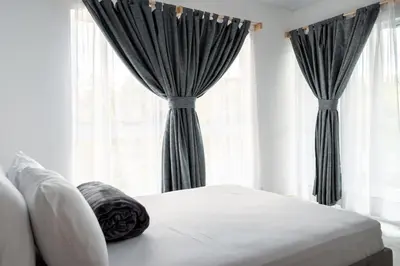a bedroom with a bed and a window with curtains at Hotel Nova El Peñol in El Peñol