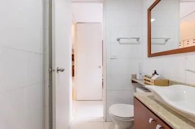 a bathroom with a toilet and a sink and a mirror at Central, Fast WiFi, AC and Poblado Views in Medellín