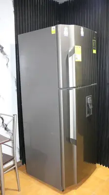 a stainless steel refrigerator sitting in a room at Hermosa casita cerca al centro in Medellín