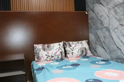 a bed with a wooden headboard and two pillows at Hermosa casita cerca al centro in Medellín