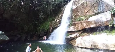 people swimming in a pool in front of a waterfall at Casa linda San Carlos in San Carlos