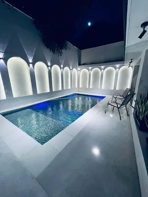 a swimming pool in a building with chairs around it at Las Lomas Luxury House2 in Medellín