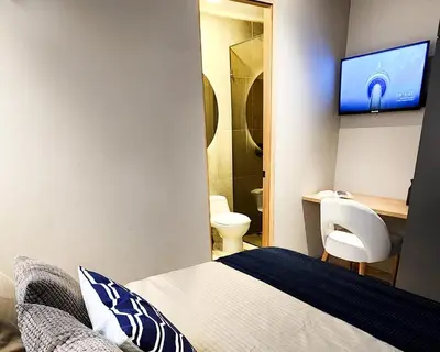 a hotel room with a bed and a tv on the wall at Las Lomas Luxury House2 in Medellín