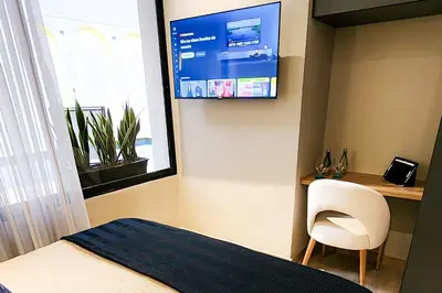 a bedroom with a bed and a tv on the wall at Las Lomas Luxury House2 in Medellín