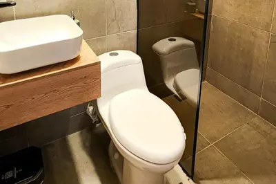 a bathroom with a white toilet and a sink at Las Lomas Luxury House2 in Medellín