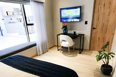 a bedroom with a desk and a tv on a wall at Las Lomas Luxury House2 in Medellín