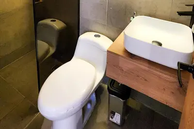 a bathroom with a white toilet and a sink at Las Lomas Luxury House2 in Medellín